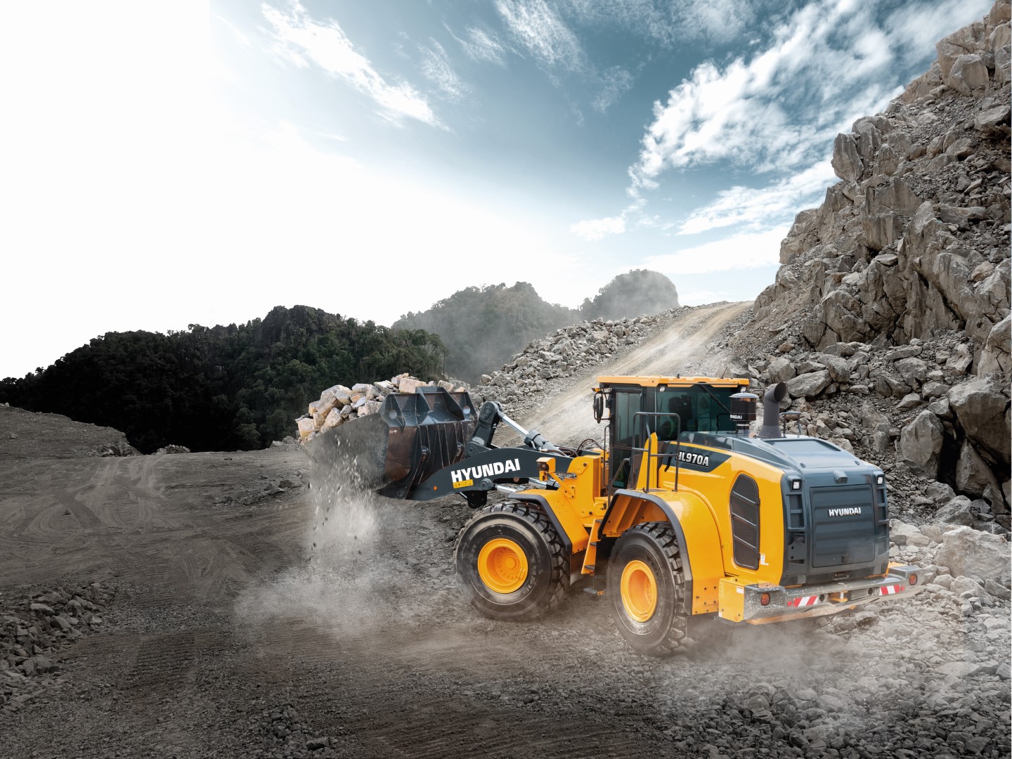 De betrouwbare Cummins L9 Stage V-motor van de HL970 levert een enorme hoeveelheid vermogen om het zware werk onder extreme omstandigheden te kunnen uitvoeren. De motor is verder voorzien van een ruim aantal technologieën die het brandstofverbruik verminderen, waarbij schadelijke emissies tot een minimum beperkt blijven. Met de nauwkeurige bedieningssystemen haalt u het maximale uit deze indrukwekkende machine, waaronder geoptimaliseerde vermogensafstemming voor een ultieme balans tussen koppel en toerental. Wanneer in de Power Smart- modus wordt gewerkt, levert de motor een brandstofbesparing tot 5% met behoud van soepele prestaties tijdens werkzaamheden met hoge belastingen, zoals graven. De in eigen beheer ontwikkelde weegsysteemtechnologie van Hyundai is standaard geïntegreerd. Met behulp van de extra bedienings-, bewakings- en onderhoudsfuncties kunt u de prestaties en productiviteit elke dag optimaliseren, op elke werklocatie